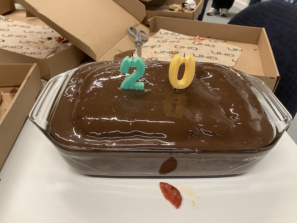 a cake with 2 candles on it: a two and a zero